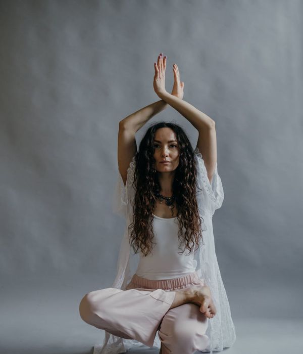 Woman in a graceful yoga pose with aquamarine light, symbolizing tranquility and balance.